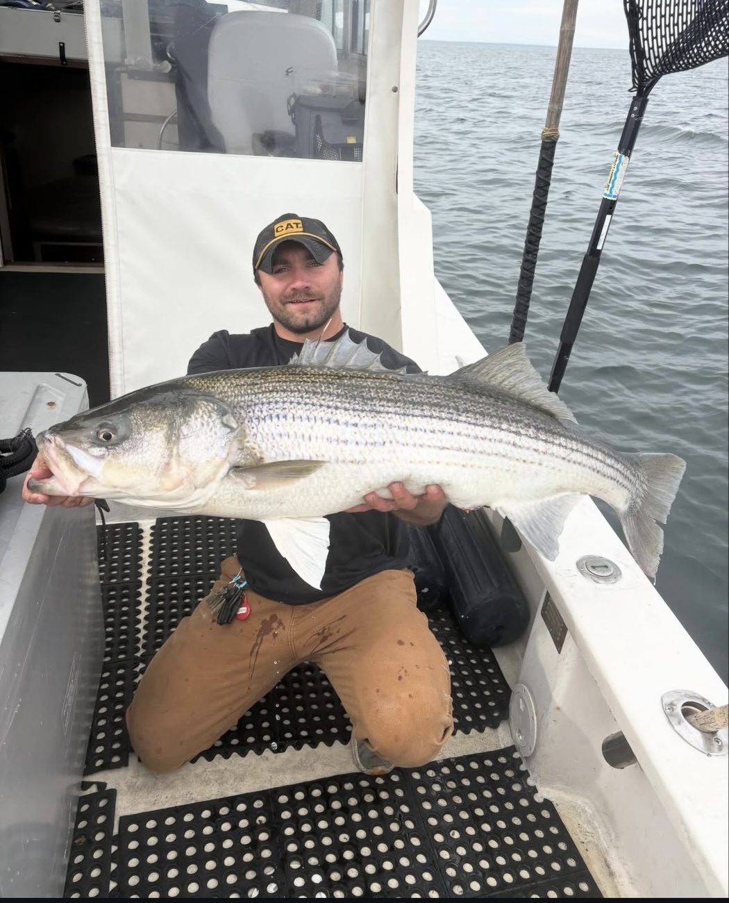 Capt. Renz Conlon with a trophy striped bass aboard Chief